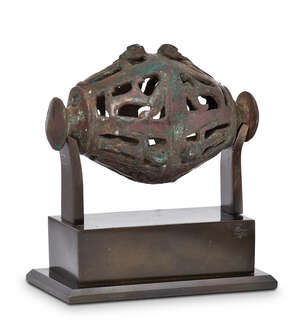 A Bactrian openwork bronze rattle, 3rd-2nd millennium B.C., of grenade form, with circular knop either end, the openwork in the form of a series of figures wit