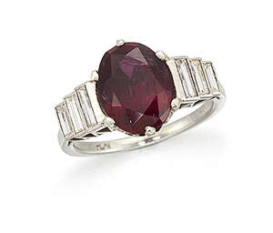 A platinum, ruby and diamond ring, the single claw-set oval-cut ruby with baguette diamond three...