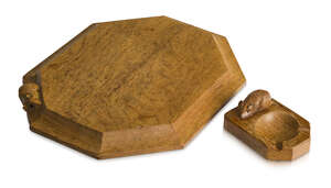 Robert Thompson (1876-1955), a Mouseman English oak cheese board and an ashtray
		c.1970, both carved with a mouse
		The octagonal board with raised and adze