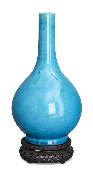 A Chinese porcelain monochrome bottle vase, Qianlong period, covered in a pale turquoise glaze, unmarked, 31cm high, on carved hardwood stand
		 
		Provenan