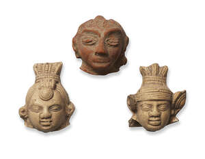 Three small stone heads, India, Gupta period, moulded with wide elongated eyes, two with elaborate headdresses, one with curls and a top knot, 3.5cm. 4cm. and 