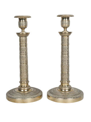 
	
		A pair of Empire ormolu candlesticks, early 19th century, each with campana urn nozzles...
