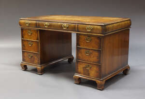 
	
		An Edwardian walnut pedestal desk, the rectangular top inset with brown leather writing...