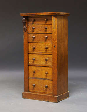 
	
		A Victorian oak Wellington chest, with carved foliate corbel and seven graduated drawers,...