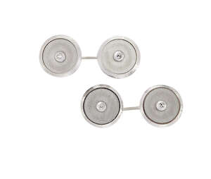 A pair of diamond cufflinks, the circular panels with raised single-cut diamond single stone centres to chain link fittings, each panel with matt finish and ra
