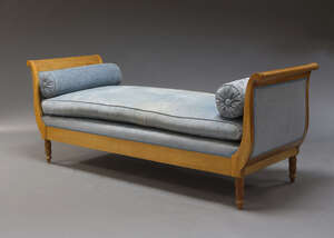 
	
		A Biedermeier style day bed, early 20th Century, with scrolling ends, upholstered in blue...