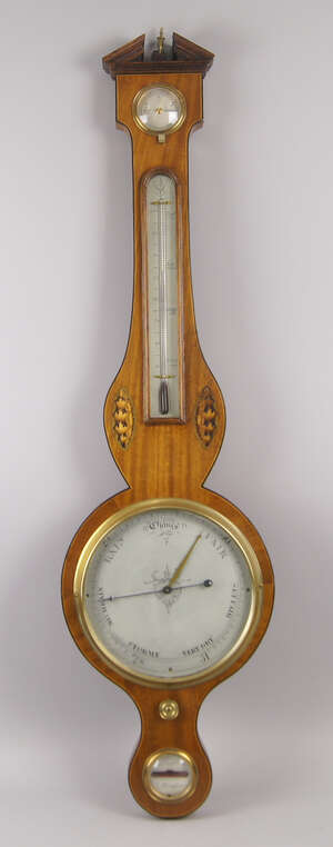 
	
		An Edwardian George III style inlaid wheel barometer, with a brass urn finial and broken...