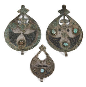 
	
		Three Seljuq turquoise-set and nielloed silver pendants, Iran, 12th century, each of drop...