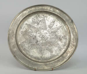 
	
		A Continental pewter charger, probably 18th century, engraved with a six point star with...