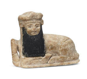 A rare Mesapotamian limestone figure of a recumbant bull, early Bronze age, mid-3rd millenium B.C., the beard possible added later, formerly with inlaid eyes, 