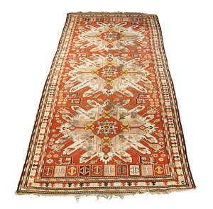 
	
		A Kazak rug, early 20th century, with three ivory double eagle medallions in a red field,...