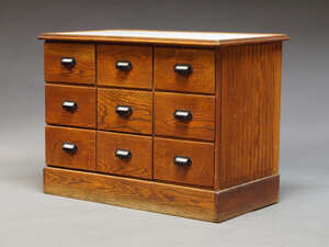 
	
		An American oak shop cabinet, mid 20th century, the rectangular tops inset with white...