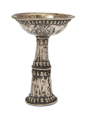 
	
		A Tibetan silver butter lamp, 18th/19th century, decorated with five bands of skulls, the...