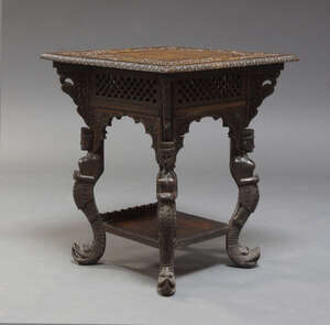 
	
		An Indian hardwood occasional table, late 20th Century, the square top carved with lions...