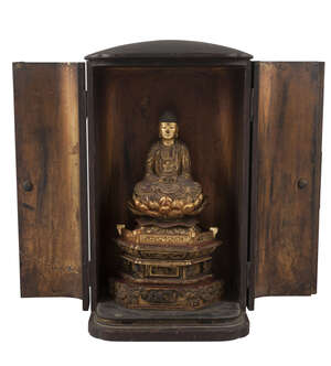 
	
		A Japanese zushi, Edo period, housing a carved giltwood buddha seated on a lotus throne,...
