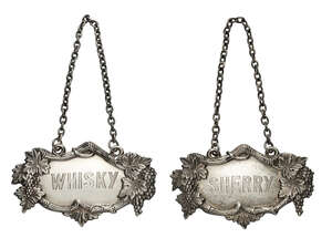 RTO:  An Indian Colonial silver wine bottle label, 'Sherry', Dhiren Das, Calcutta, with moulded vine and grapes border, together with a similar 'Wh