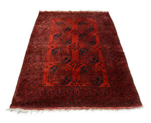 
	
		An Afghan rug, mid to late 20th century, with two rows of octagons in a deep red field,...