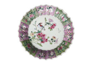 A Chinese porcelain fluted dish, Qianlong period, painted in famille rose enamels with a bird amidst floral sprays, inside a border of floral painted panels, u