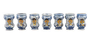 A group of seven Italian maiolica miniature albarelli, 19th century, each decorated with a cartouche flanked by winged putto, various spurious dates 1689, 1710