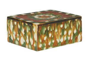 A Chinese sancai-glazed pottery pillow, Tang dynasty, the top and underside decorated with an incised flowerhead encircled by stylised ruyi-form petals, the si
