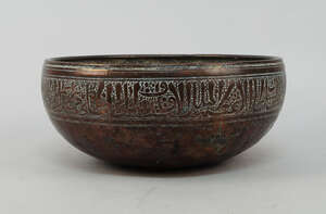
	
		An Islamic copper bowl, 18th/19th century, engraved with a line of script to the rim,...