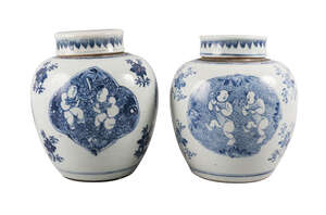 A pair of Chinese porcelain jars and covers, Kangxi, each painted in underglaze blue with quatrilobe panels of boys playing on a ground decorated with lotus fl