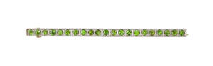 An Edwardian demantoid garnet brooch, composed of a line of circular-cut demantoid garnets, mounted in gold with platinum front, length 5.6cm, in case