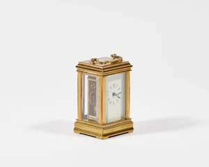 A French brass 'mignonette' carriage timepiece, early 20th century, with shaped swing handle...