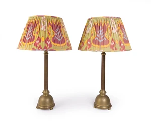 A pair of modern brass twin light table lamps, each with knopped stem on domed base with three bun feet, with pleated fabric shade by Robert Kime Ltd., 63cm hi