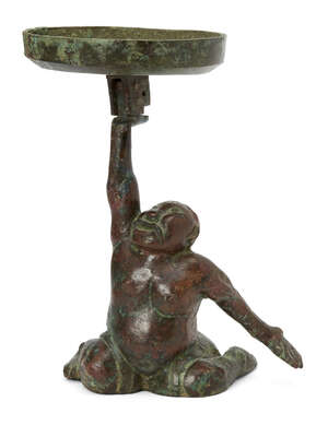 A Chinese bronze figural candleholder, Western Han dynasty, cast as a kneeling 'entertainer' holding a disc in his right hand for the pricket, partiall