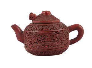 
	
		A Chinese cinnabar lacquer encased Yixing teapot, late Qing dynasty, carved to the body...