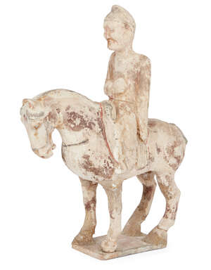 A Chinese pottery painted figure of a horse and rider, Sui dynasty, the horse standing four square, the rider with right arm across body and with clenched fist