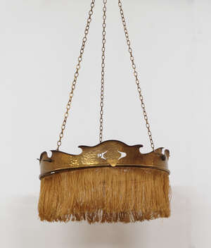 
	
		An Art Nouveau hammered and pierced circular ceiling light, hung with tassels to the rim,...