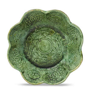 A Chinese green-glazed pottery 'lotus pond' lobed bowl, Liao dynasty, 10th/11th century, moulded to the central reserve with a lotus flower encircled b