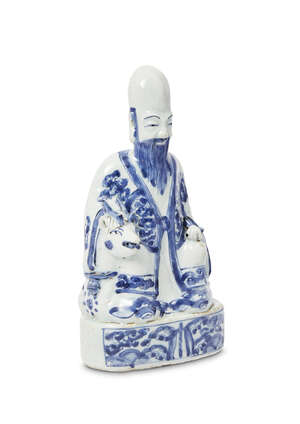 A Chinese porcelain figure of Shoulao, Ming dynasty, Wanli period, modelled seated on a recumbent deer raised on oval base, clutching a scroll, painted in unde
