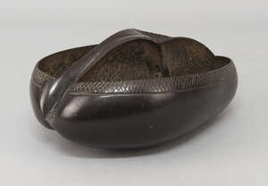 
	
		A Coco de Mer basket, late 19th century, with an integral handle, decorated with incised...