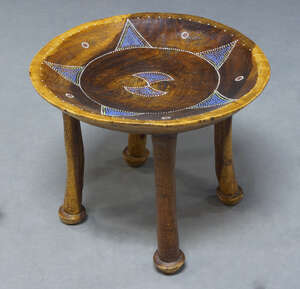 
	
		A tribal circular stool, with a dished top decorated with geometric beadwork, on four...