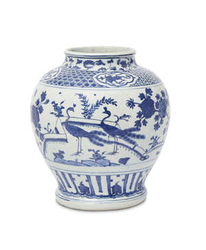 A large Chinese porcelain jar, guan, Ming dynasty, Jiajing period, painted in underglaze blue with three peacocks in a continuous garden landscape beneath a bo