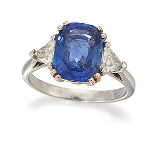 
	
		A sapphire and diamond three stone ring, the cushion shaped sapphire centre between...