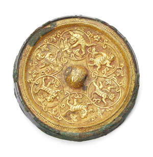 A rare Chinese bronze gold inlaid circular mirror, Tang dynasty, inlaid with a gold sheet finely chased with a raised central floral knop encircled by tigers a