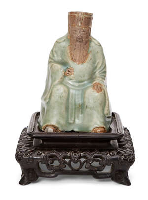 
	
		A Chinese Longquan celadon and biscuit figure, Ming dynasty, moulded and incised as a...