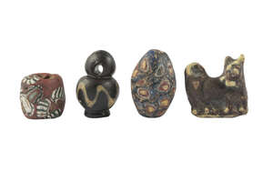 A group of four Romano-Egyptian items, 1st-4th century AD, including a conical glass mosaic bead, a glass amulet of a dog, another round glass mosaic bead, and