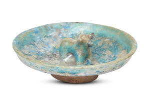 
	
		A Kashan turquoise-glazed pottery dish with moulded bull, Iran, 12th century, on a short...