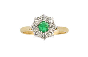 
	
		An emerald and diamond cluster ring, the central circular-cut emerald within a...