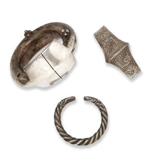 
	
		Three silver bracelets, Iran, 14th-17th century, the first of rounded form, with...