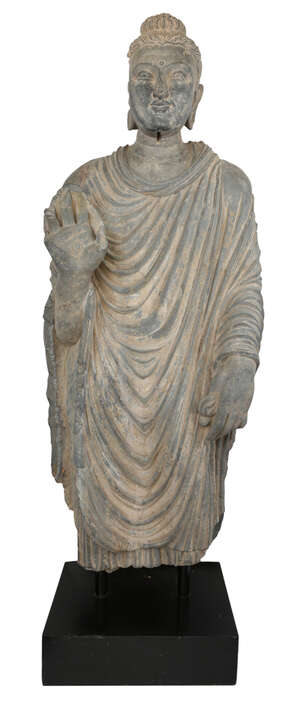 A Gandhara life size standing standing figure of Buddha, 2nd/3rd century, wearing a full length...