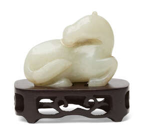 
	
		A Chinese pale green jade horse, late 19th century, carved in recumbent pose with head...