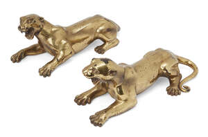 
	
		A pair of Tibetan polished bronze tigers, early 20th century, each modelled in recumbent...