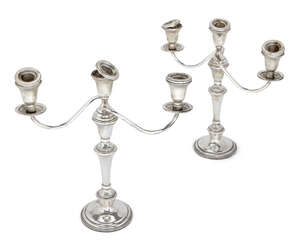 A pair of three-branch candelabra candlesticks, bases stamped 'weighted sterling', each candlestick raised on a spreading circular foot to knopped stem