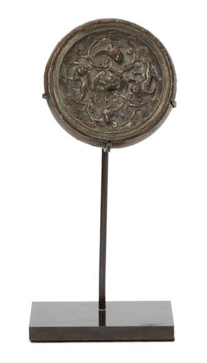 A Chinese miniature silver sheet-inlaid bronze circular mirror, Tang dynasty, the bronze mirror inlaid with a silver sheet finely chased with a central crouchi